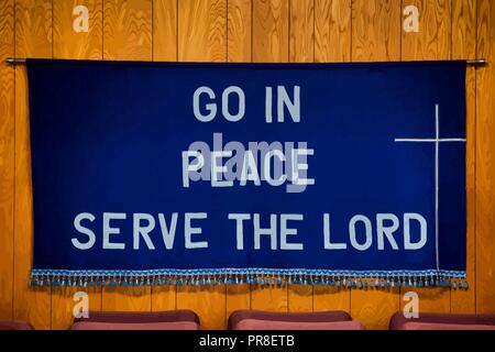 `Go in Peace Serve the Lord` written on Dark Blue Cloth with white cross on the right side, tassels all along the bottom of the cloth. Stock Vector